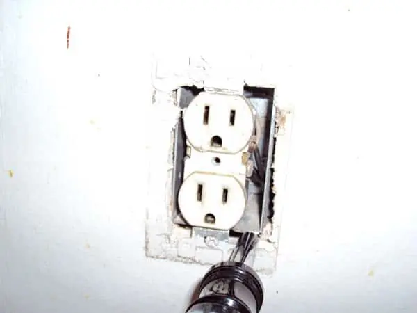 Screwdriver Inserted Under Outlet Box